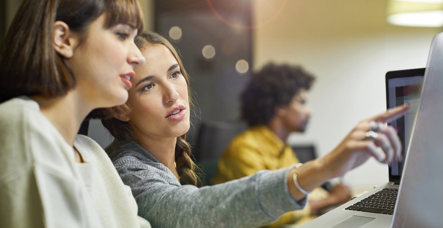 Women working on digital interfaces.webp