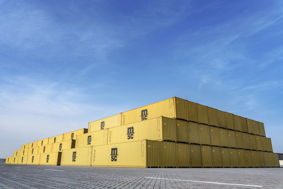 Stacks of MSC shipping containers in a container yard, representing global cargo movement and real-time container tracking